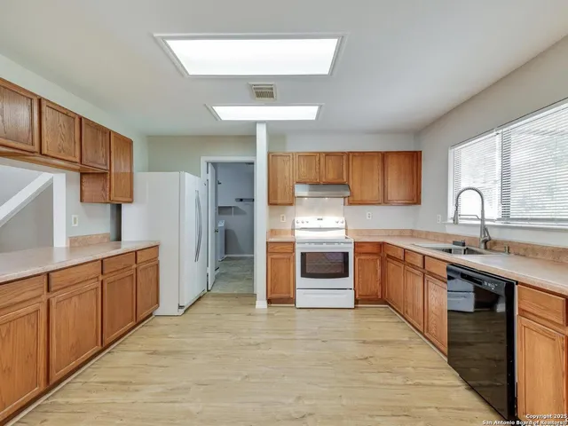 a large kitchen with stainless steel appliances kitchen island granite countertop a stove refrigerator and cabinets