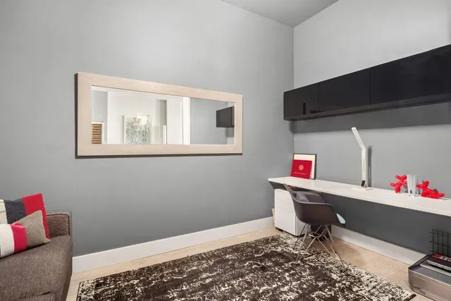 a living room with furniture and a painting on the wall