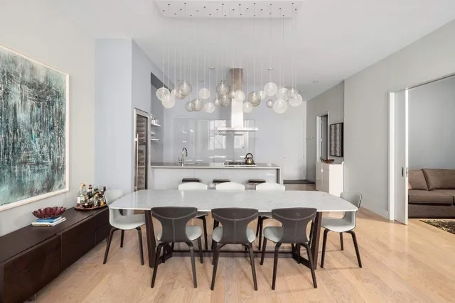 a living room with stainless steel appliances kitchen island granite countertop a table chairs in it and a large window