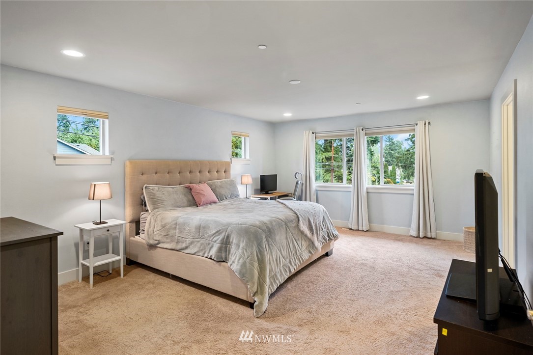 2313 242nd Place Southwest Bothell, WA 98021 - Photo 14 of 27 a spacious bedroom with a bed and a flat tv screen on the dresser