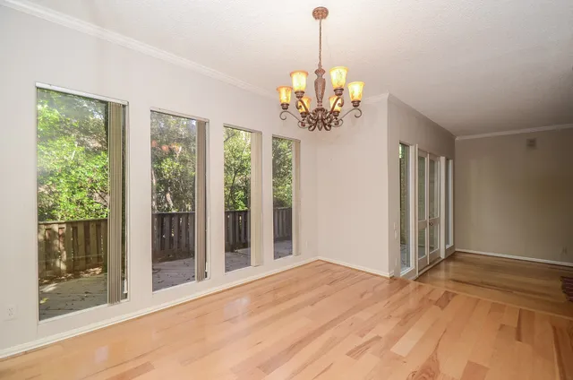 a view of a room with a large window and chandelier