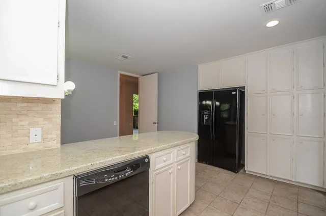 a kitchen with stainless steel appliances granite countertop a refrigerator and a sink
