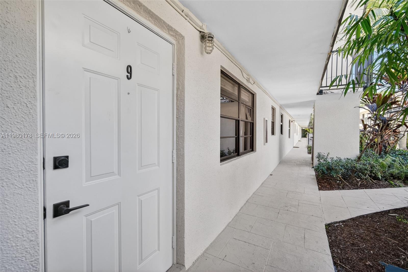 3265 Virginia Street, Unit 9 Miami, FL 33133 - Photo 16 of 32 a view of a hallway with potted plants in front of door