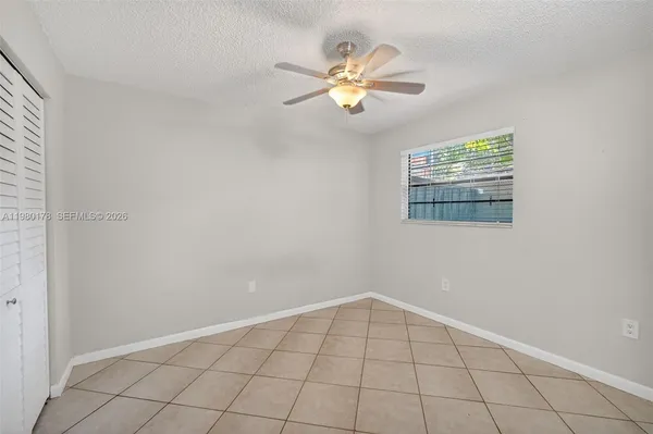 an empty room with windows and fan