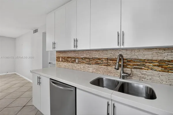 a view with kitchen island sink and refrigerator