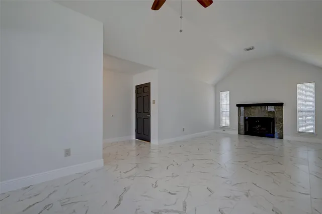 a view of a room with a hanging light and kitchen view