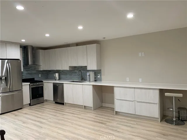 a kitchen with granite countertop a stove top oven and cabinets