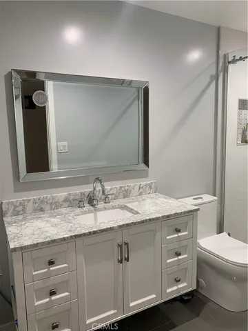 a bathroom with a granite countertop sink and a mirror