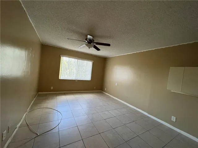 a view of empty room with projector and fan