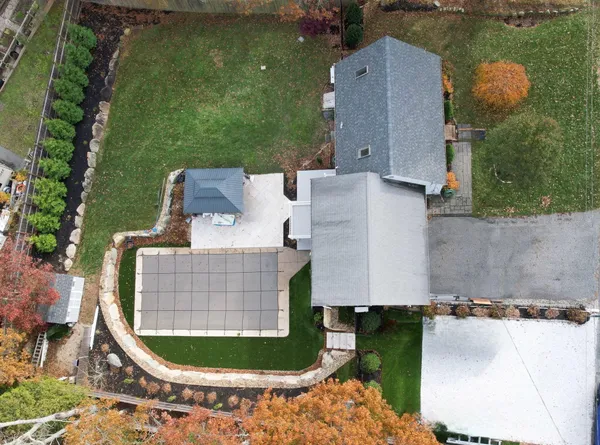 an aerial view of a house with outdoor space and a lake view in back