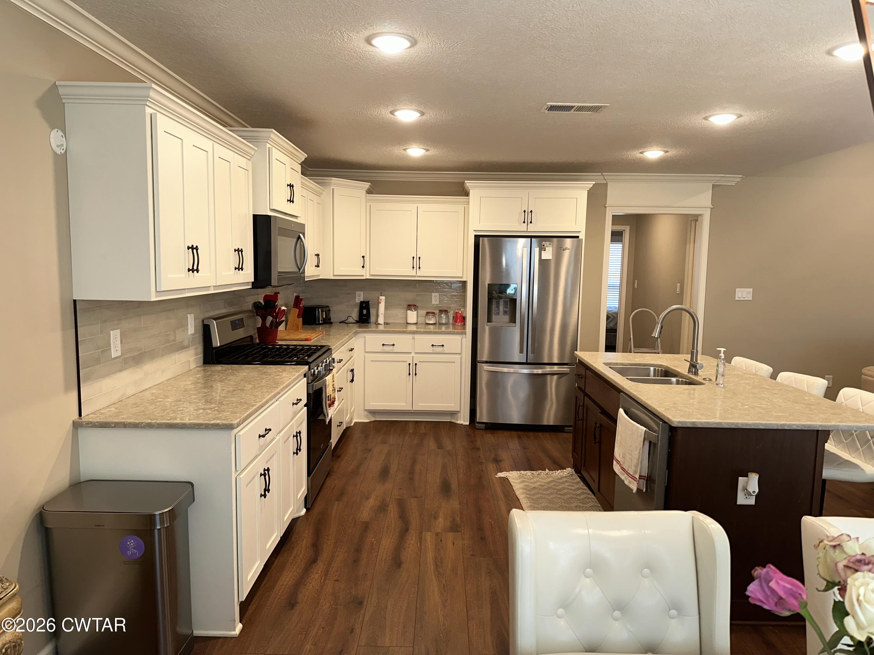 103 Gatewick Drive Jackson, TN 38305 - Photo 6 of 29 a kitchen with granite countertop a sink stove refrigerator and cabinets