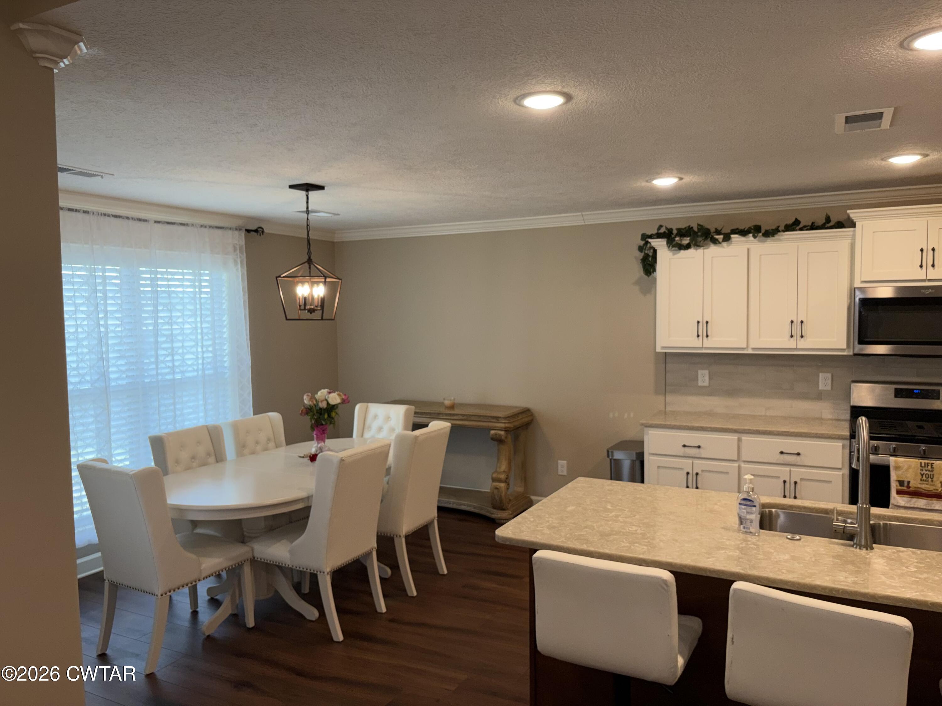 103 Gatewick Drive Jackson, TN 38305 - Photo 10 of 29 a kitchen with a dining table chairs and white cabinets
