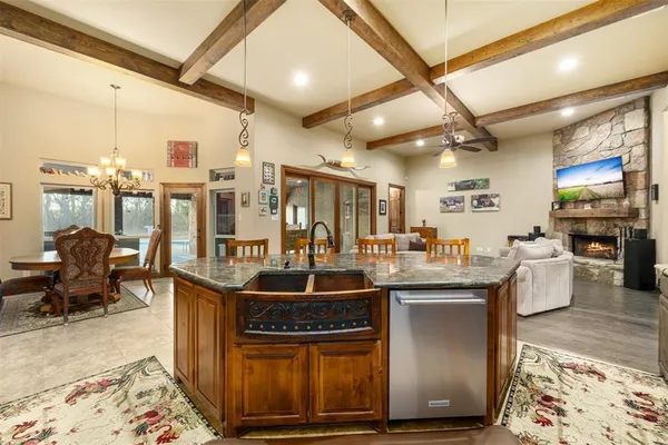 a room with stainless steel appliances kitchen island granite countertop furniture a rug and a view of living room