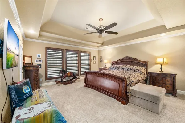 a spacious bedroom with a bed a couch and a chandelier
