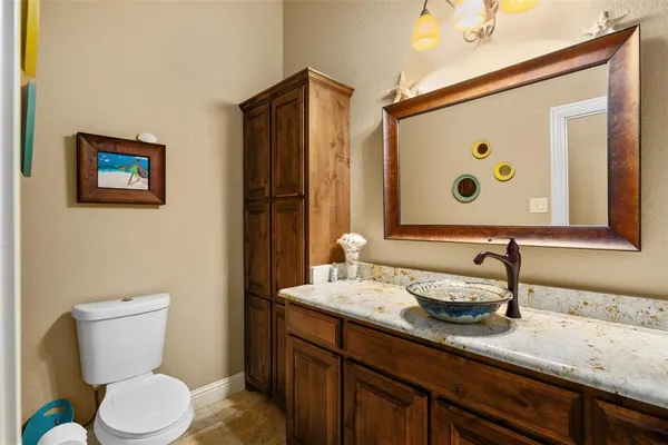 a bathroom with a granite countertop sink mirror and toilet