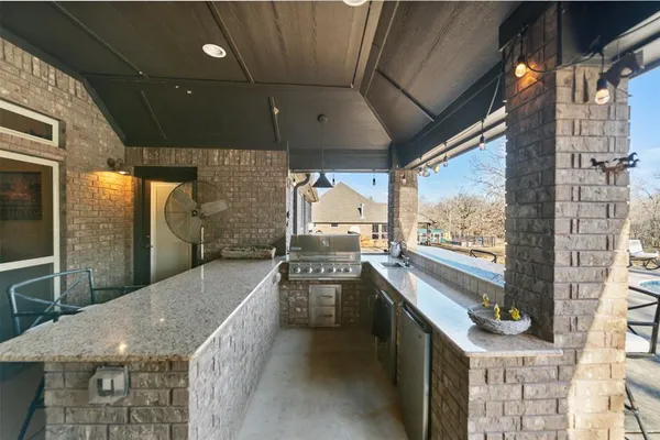 a kitchen with a sink a counter top space stainless steel appliances and cabinets