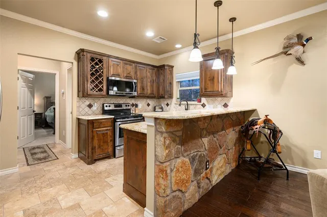 a kitchen with stainless steel appliances kitchen island granite countertop a sink and a refrigerator