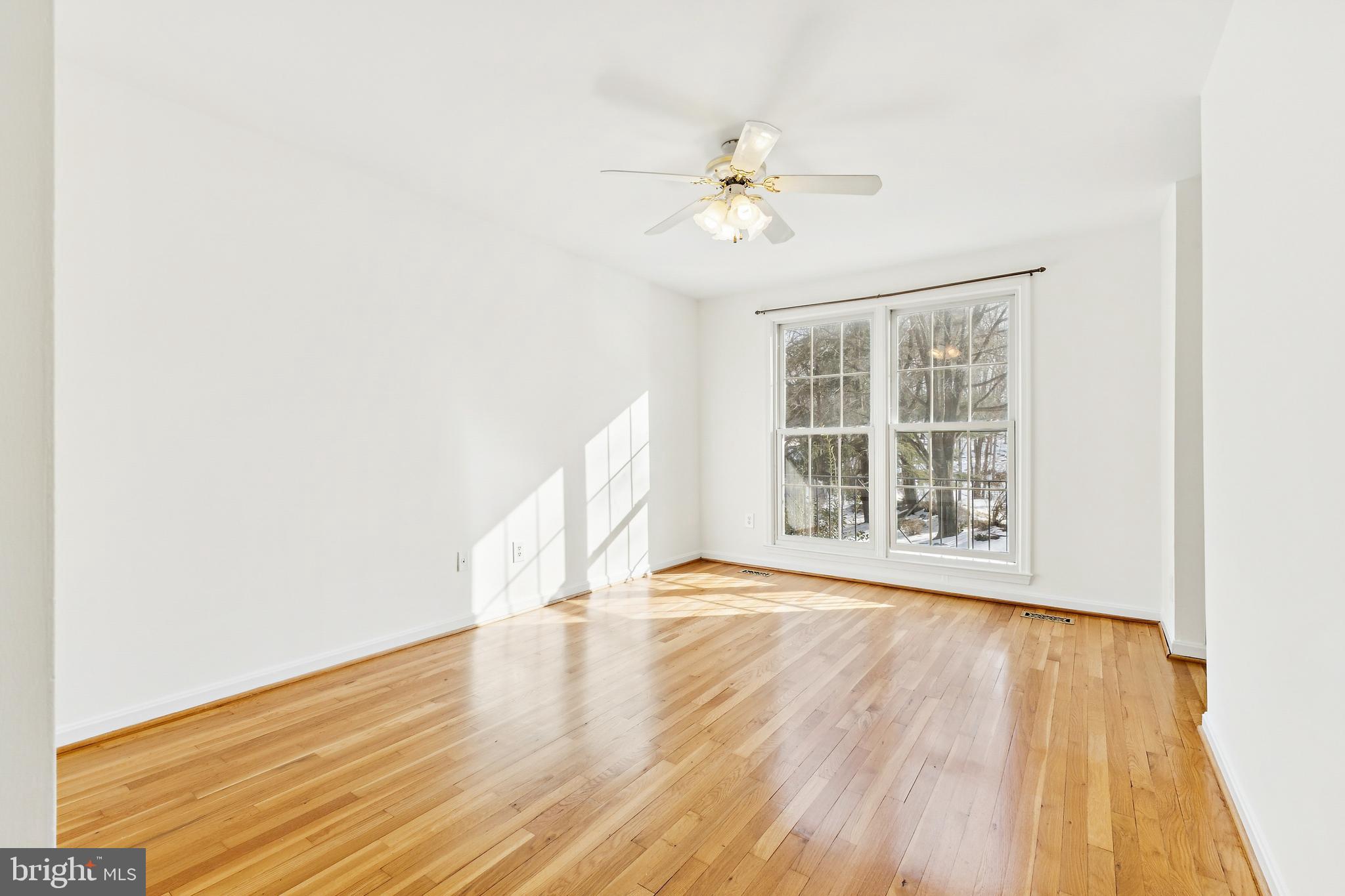 9896 Cardinal Road Fairfax, VA 22030 - Photo 18 of 44 a view of an empty room with wooden floor and a window