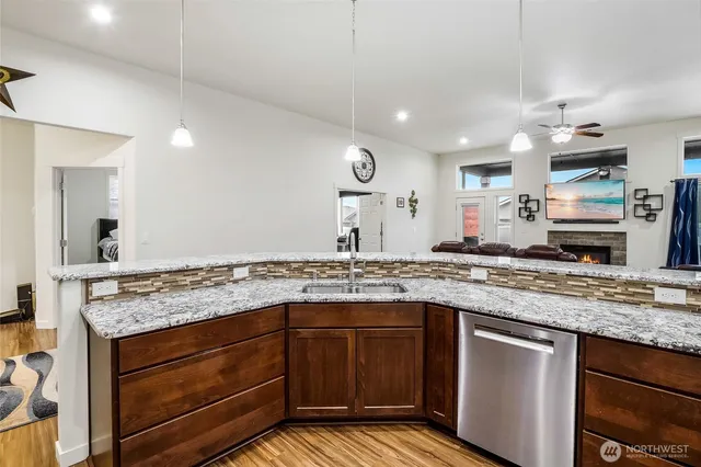 a kitchen with granite countertop stove sink and microwave