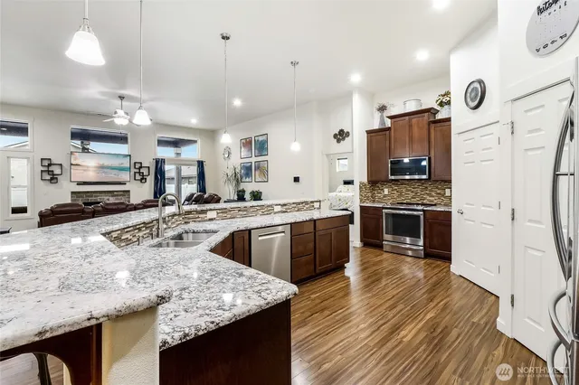 a kitchen with stainless steel appliances granite countertop a stove refrigerator and a sink