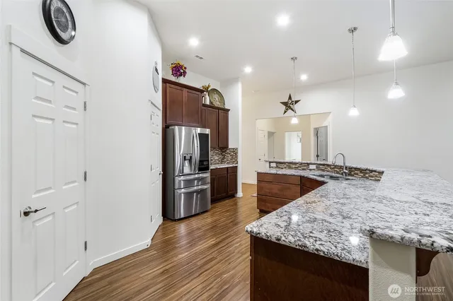 a kitchen with stainless steel appliances granite countertop a sink a stove and a refrigerator