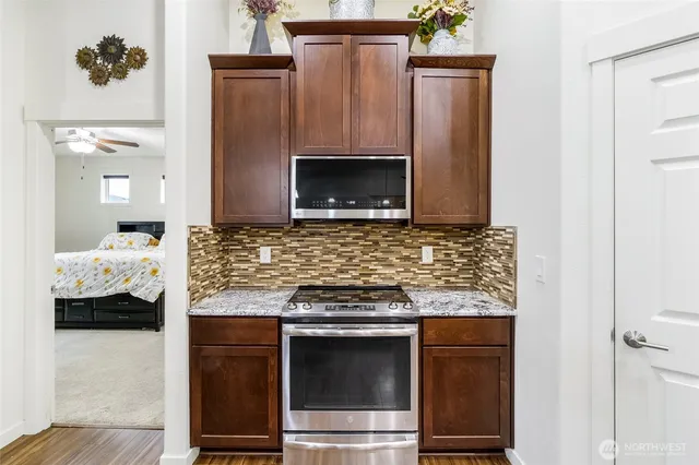 a kitchen with granite countertop white cabinets and stainless steel appliances