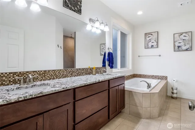 a bathroom with a granite countertop sink and a bathtub