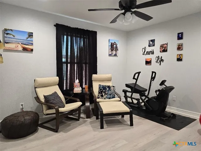 a living room with furniture and a ceiling fan