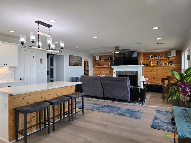 a living room with furniture a fireplace and kitchen view