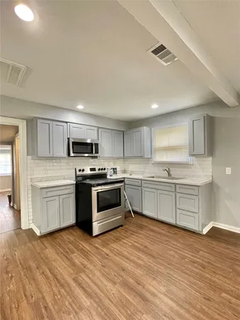 a kitchen with a white stove top oven and cabinets