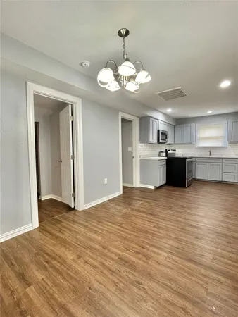 a view of a kitchen with a stove cabinets a wooden floor and a kitchen