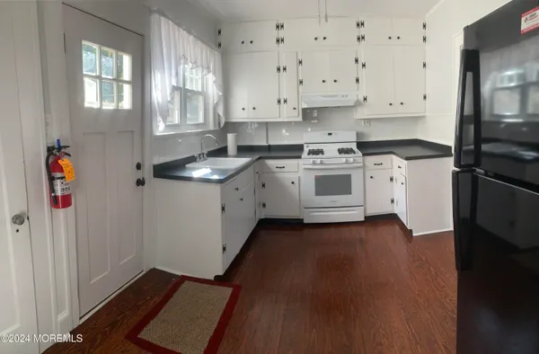 a kitchen with granite countertop white cabinets and white appliances