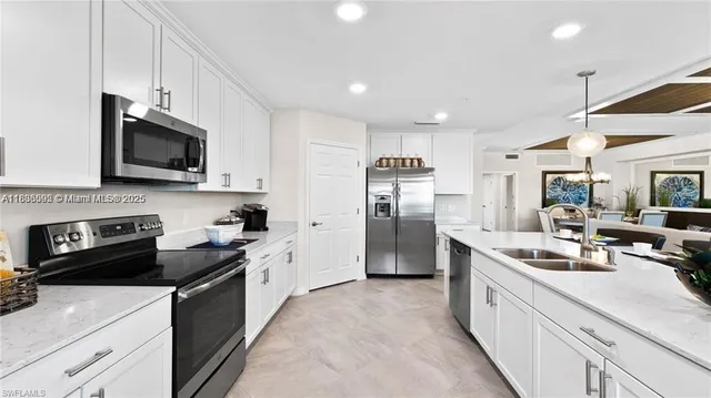 a living room with furniture kitchen view and a chandelier