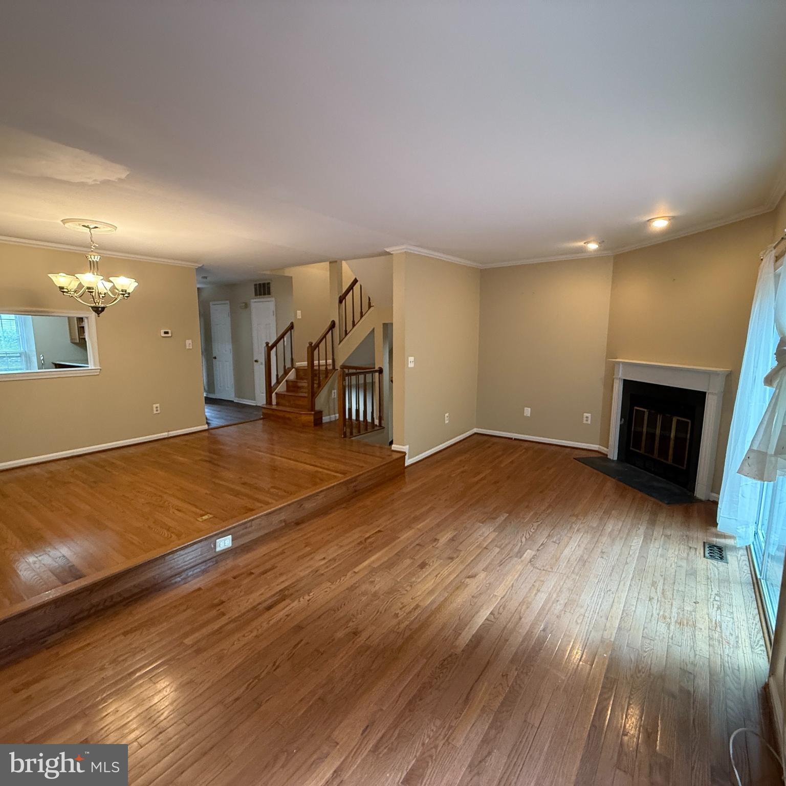 8222 Maple Ridge Avenue Springfield, VA 22153 - Photo 5 of 25 an empty room with wooden floor and fireplace
