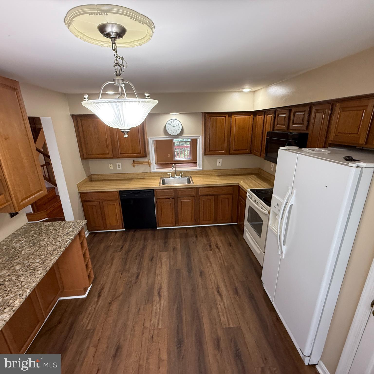 8222 Maple Ridge Avenue Springfield, VA 22153 - Photo 10 of 25 a kitchen with kitchen island granite countertop a sink a stove refrigerator and microwave