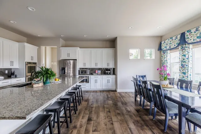 a kitchen with granite countertop kitchen island white cabinets and stainless steel appliances