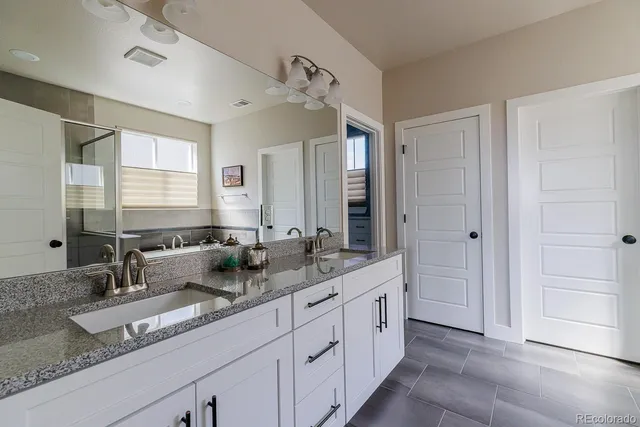 a bathroom with double sink and a mirror