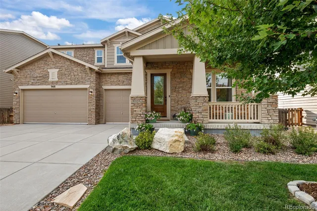 a front view of a house with a garden and plants
