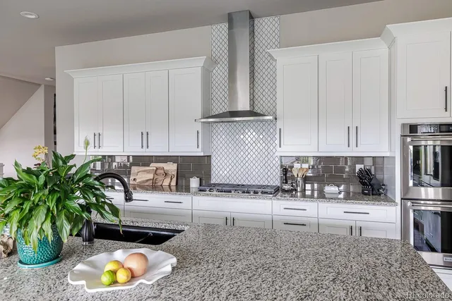 a kitchen with granite countertop a sink a stove and a wooden floors