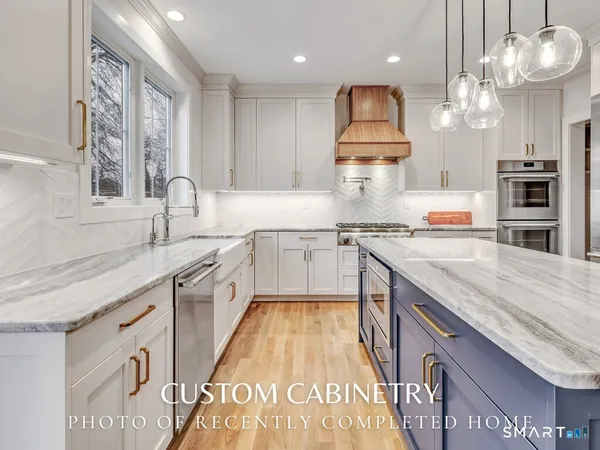 a large kitchen with stainless steel appliances granite countertop plenty wooden cabinets counter space and a window