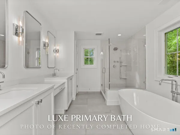 a bathroom with a granite countertop sink a large mirror a shower and bathtub