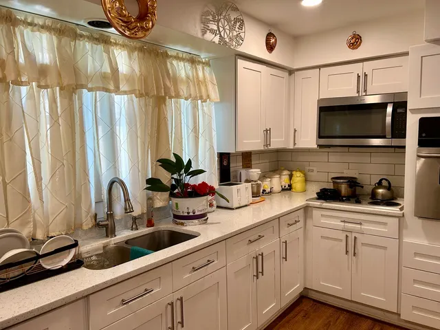 a kitchen with a sink a counter cabinets and appliances