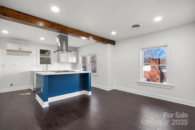 a kitchen with stainless steel appliances kitchen island granite countertop a stove a sink and a refrigerator