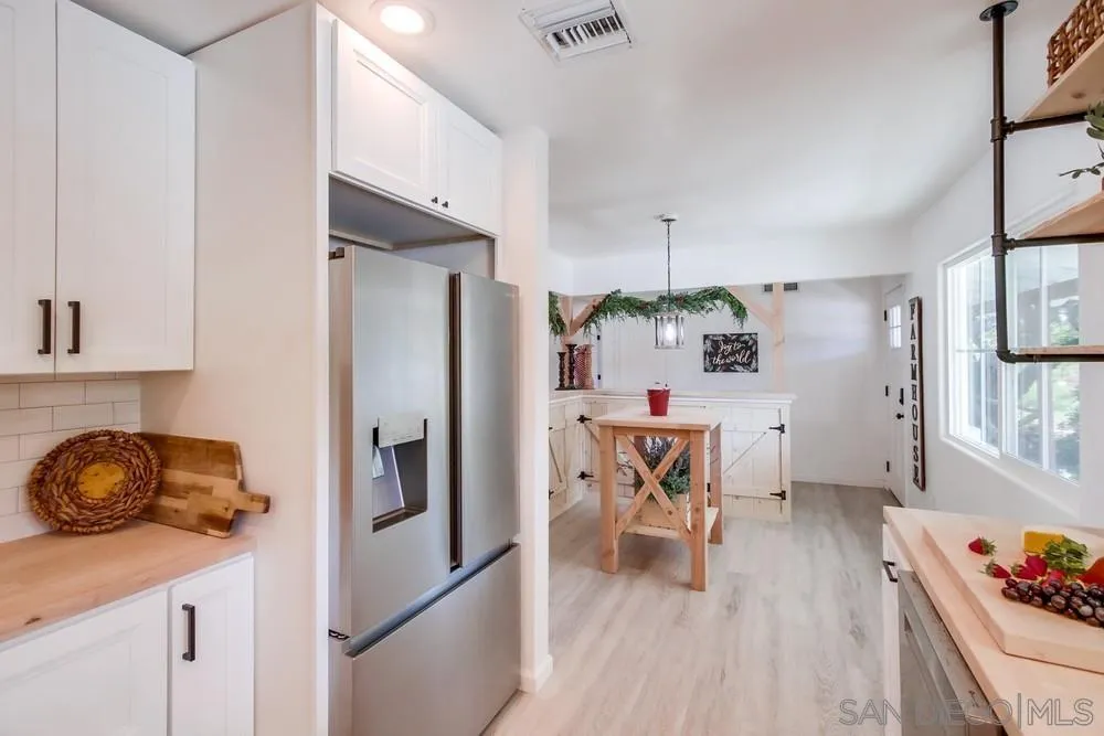 9130 Hillman Way Lakeside, CA 92040 - Photo 23 of 48 a kitchen with stainless steel appliances granite countertop a refrigerator a stove and a wooden floors