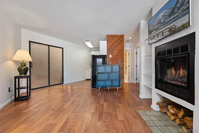 a view of an empty room with wooden floor fire place and a fireplace