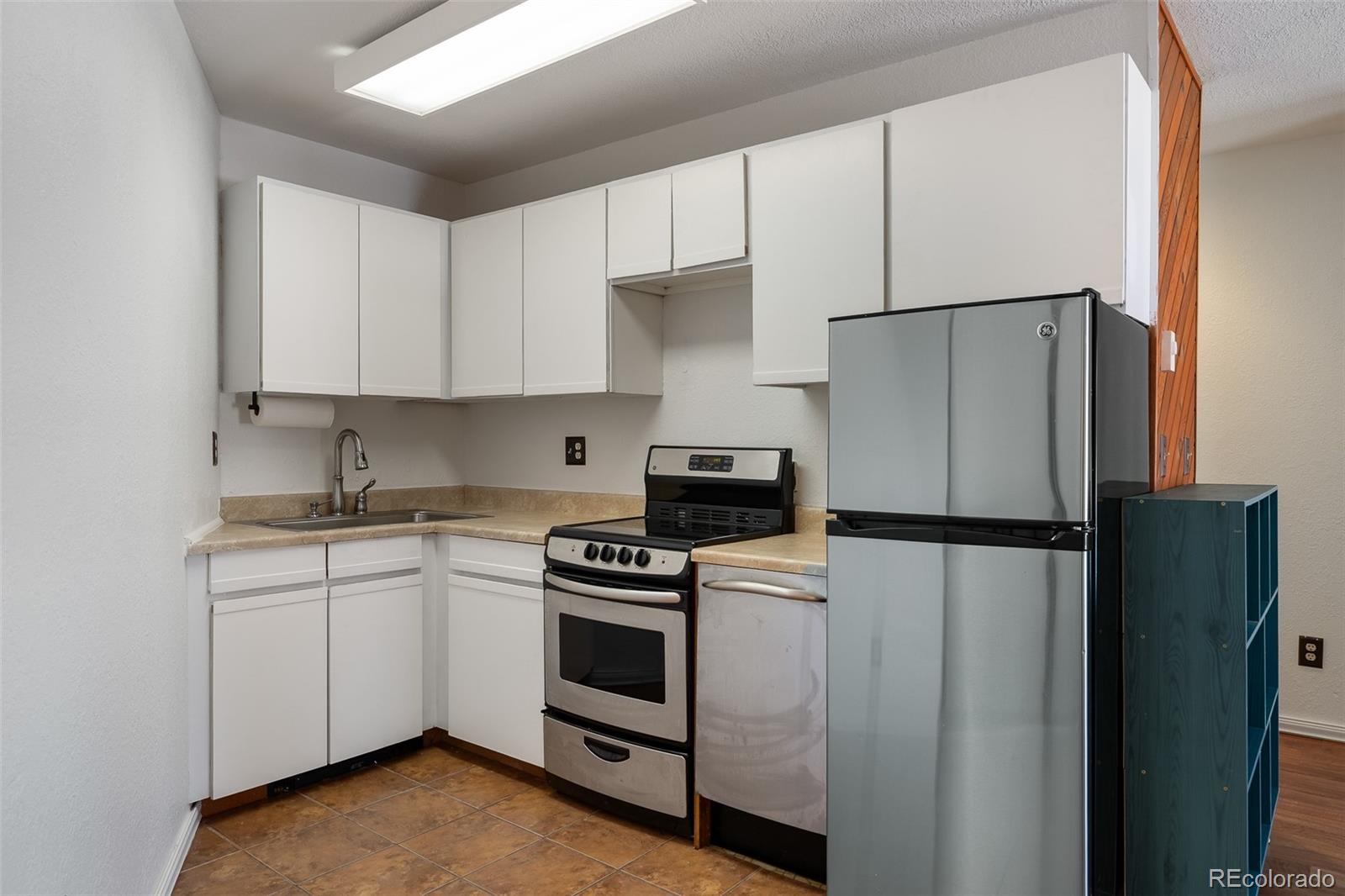 105 County Road, Unit 20 Grand Lake, CO 80447 - Photo 4 of 16 a kitchen with a refrigerator sink and white cabinets
