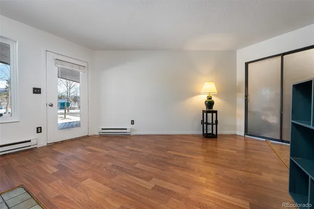 a view of empty room with wooden floor and window