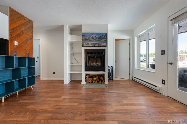 a view of an empty room with window and fire place
