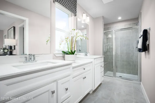 a spacious bathroom with a double vanity sink mirror and shower