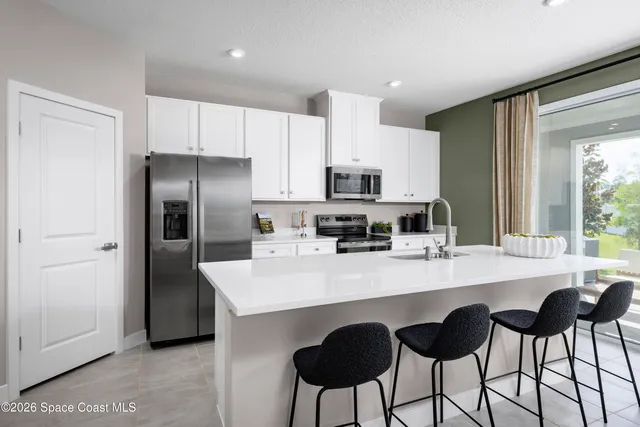 a kitchen with appliances a sink and cabinets